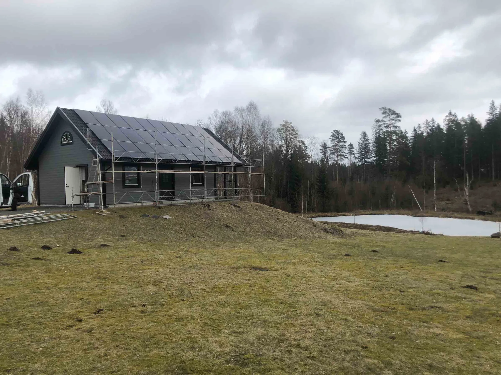 Hus med solceller på taket vid en damm