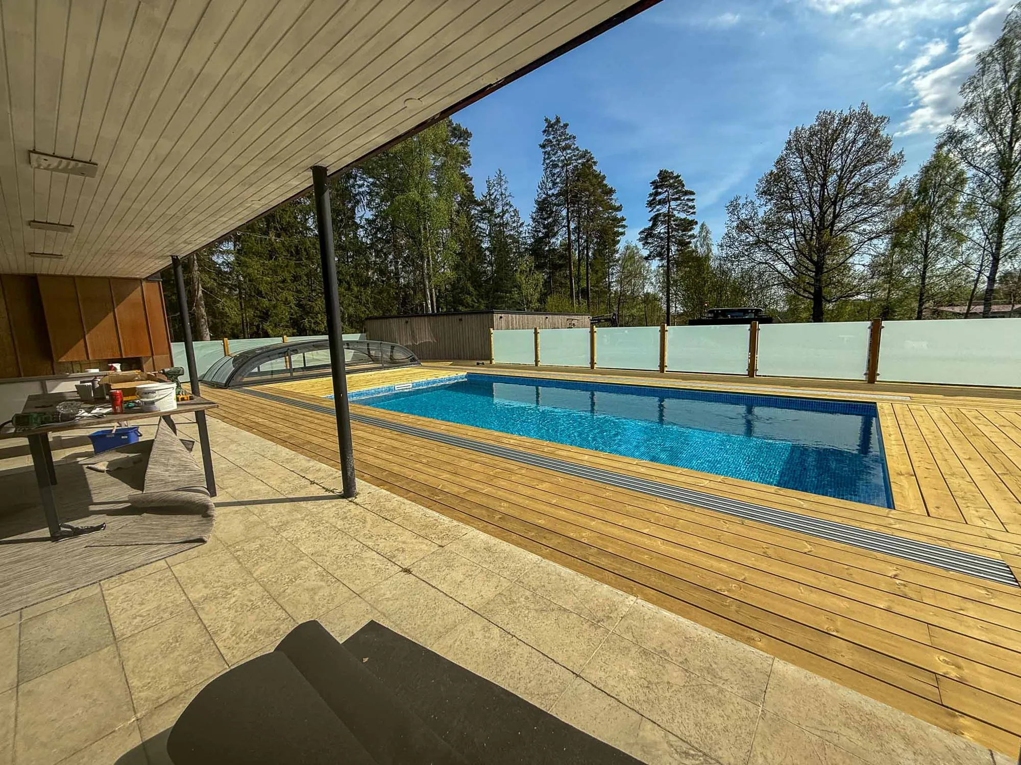 Färdig pool med trädäck och altan under tak